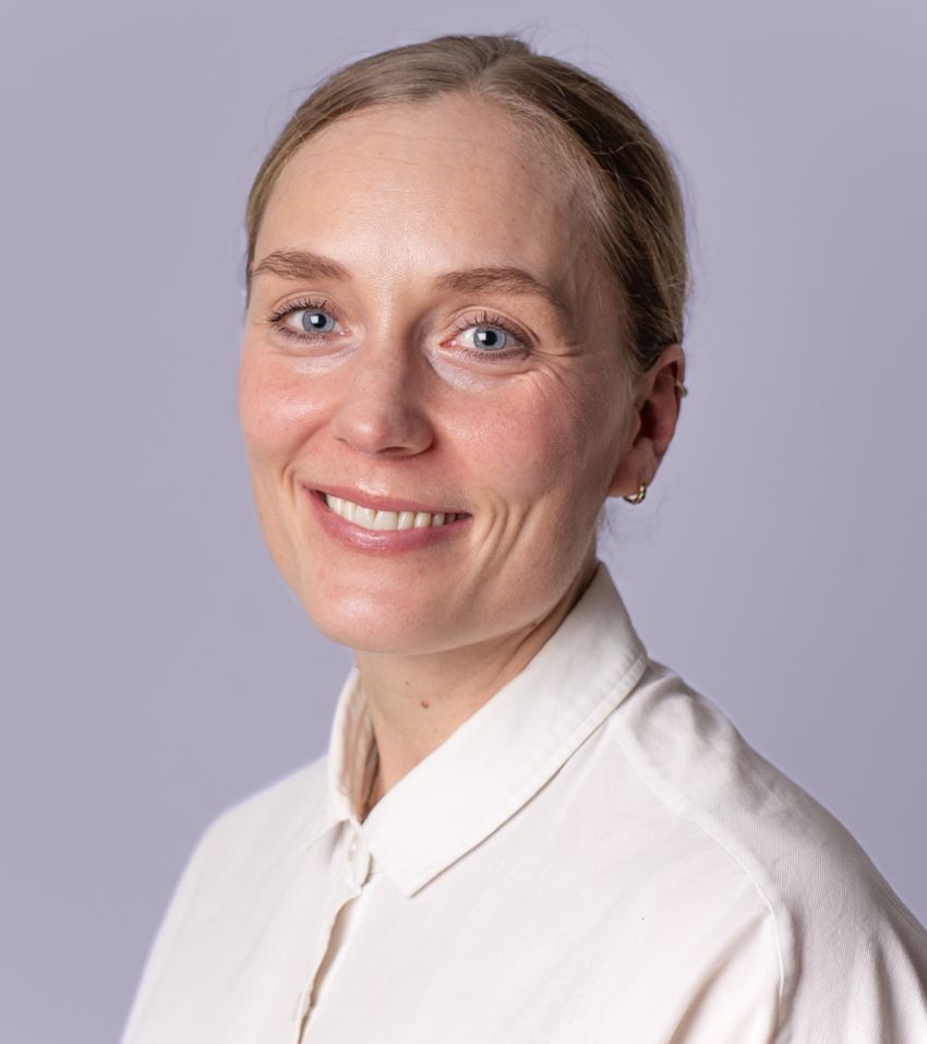A photograph of Iben Riishede wearing a white shirt against a white background.