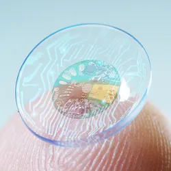 Image of macro shot of a finger holding a contact lens technology with a chip.