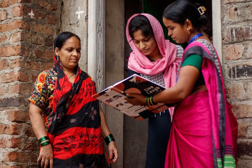 A community healthcare worker holds a booklet and discusses precautions to help reduce the risk of GDM with two women standing next to her. A community healthcare worker holds a booklet and discusses precautions to help reduce the risk of GDM with two women standing next to her.