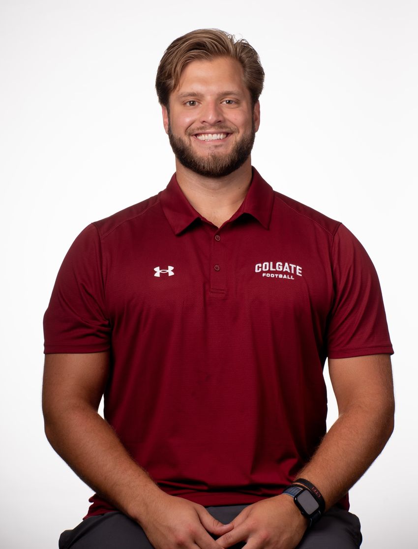 A photograph of Zachary Pelland in a maroon Colgate University t-shirt against a white background.
