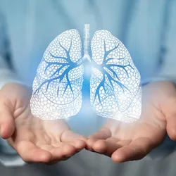 A photo of a doctor’s hands underneath an image of human lungs
