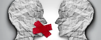 3D illustration of two human head shapes made on crumpled paper facing each other on a grey background. The head on the left has red tape covering its mouth, representing censorship. 