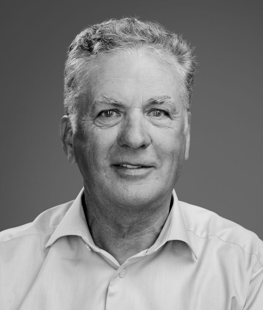 A greyscale headshot of John McHutchison, smiling in a button-down shirt. A greyscale headshot of John McHutchison, smiling in a button-down shirt.