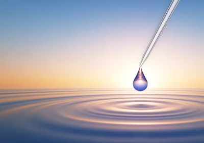 Conceptual image of a water drop released from a pipette tip, with a rippling pool of water below.