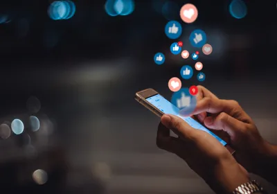 Person’s hand with a smart phone, social media concept, signifying health misinformation online.