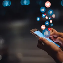 Person’s hand with a smart phone, social media concept, signifying health misinformation online.