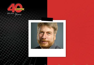 Frank Bradke wears a black shirt smiles at the camera in the TS 40th anniversary template.
