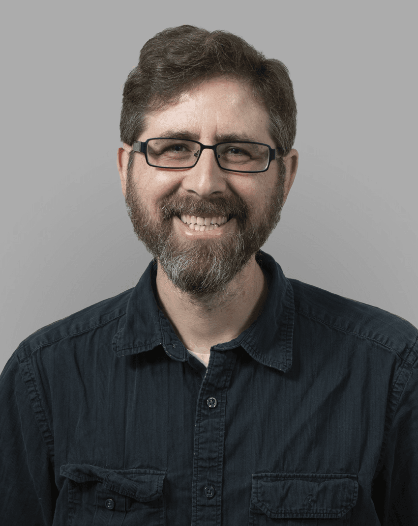 A man wearing glasses and a black shirt smile. A man wearing glasses and a black shirt smile.