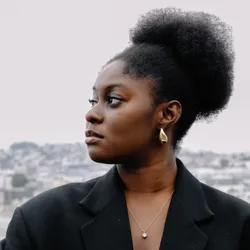 Naa Asheley Ashitey wears a black blazer and looks off to the left.