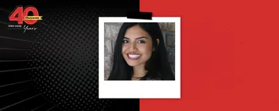 Photograph of Humsa Venkatesh against a brick wall.
