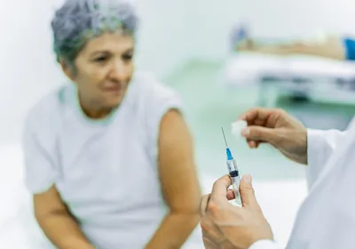 Close-up of a doctor preparing to inject a senior patient at the hospital.