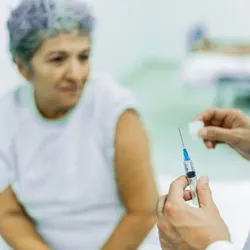 Close-up of a doctor preparing to inject a senior patient at the hospital.