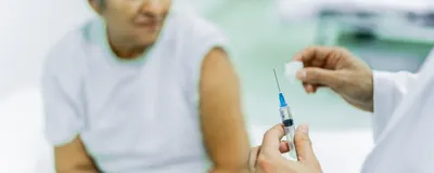 Close-up of a doctor preparing to inject a senior patient at the hospital.