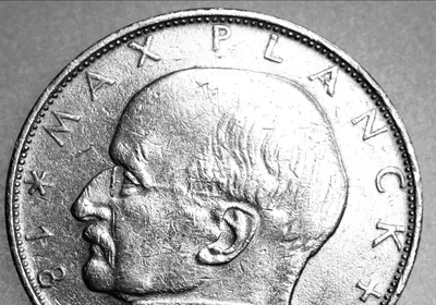 Max Planck’s profile is shown on one side of silver-colored coin.