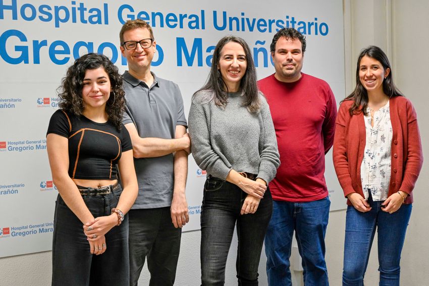 A group of people standing in front of a sign.