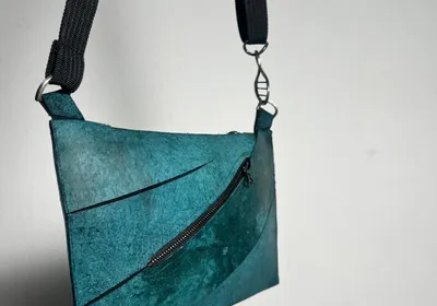 A photo of the final Enfin Levé designed teal T. rex leather purse.