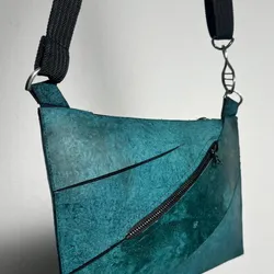 A photo of the final Enfin Levé designed teal T. rex leather purse.