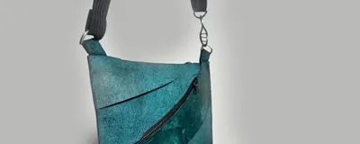 A photo of the final Enfin Levé designed teal T. rex leather purse.