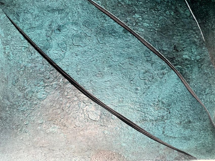 A close up of the teal-colored T. rex leather purse. A close up of the teal-colored T. rex leather purse.