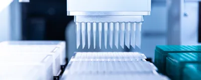 Automated pipette tips above rows of PCR plates on an instrument deck.