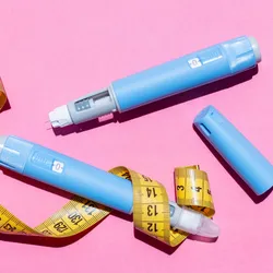 Blue Ozempic pens are shown with a yellow measuring tape on a pick background.