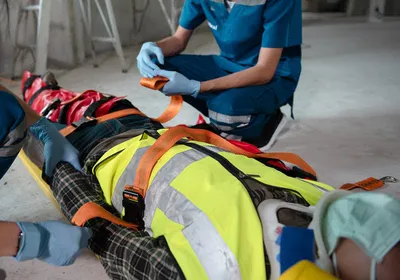 Two first responders administer first aid to an injured construction worker. TRAUMAGEL stops hemorrhage after traumatic injuries. 