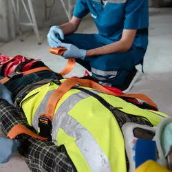 Two first responders administer first aid to an injured construction worker. TRAUMAGEL stops hemorrhage after traumatic injuries.