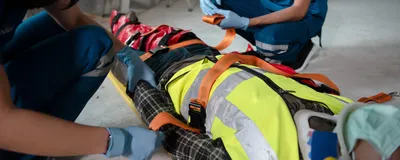 Two first responders administer first aid to an injured construction worker. TRAUMAGEL stops hemorrhage after traumatic injuries. 