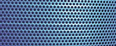 A close-up of a blue metal surface with uniform circular holes.