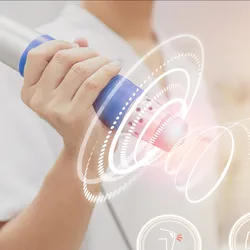 Physiotherapist using shockwave with virtual health care symbol and pain icons medical on interface, signifying ultrasound-mediated cancer therapy.