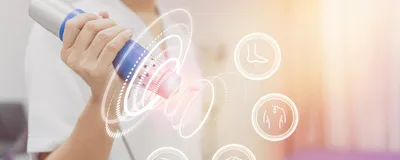 Physiotherapist using shockwave with virtual health care symbol and pain icons medical on interface, signifying ultrasound-mediated cancer therapy.