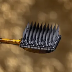 Photograph of a brain-computer interface implant, revealing an electrode array, with needle-like electrodes facing upward