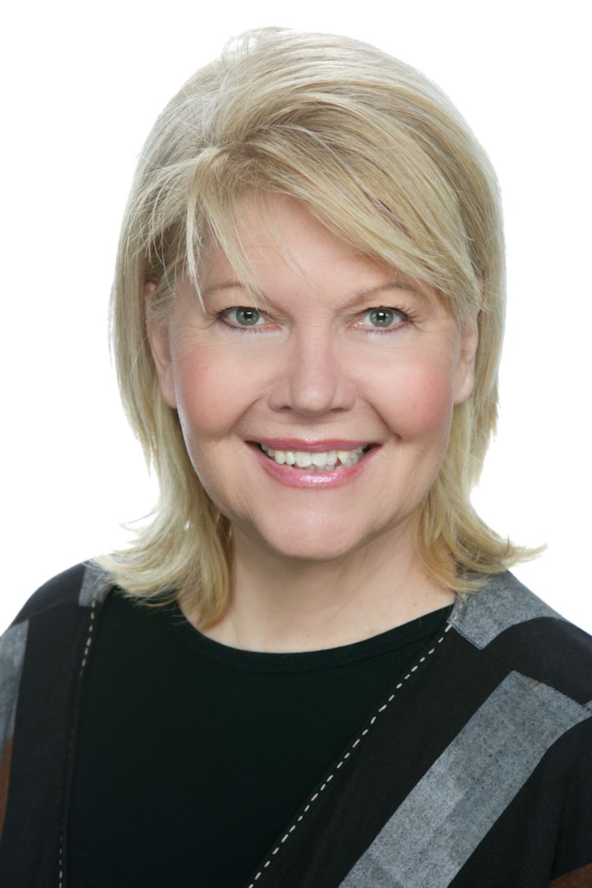 Laura Hall wears a black sweater and smiles in a headshot photo against a white background.
