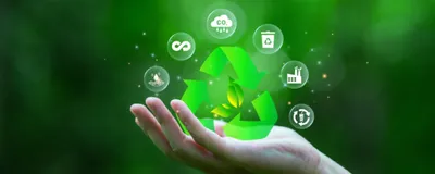 Photograph of a person’s hand raised against a background with green, leafy trees. There are icons representing concepts of recycling, reducing carbon dioxide, and reusing materials floating above the hand. 