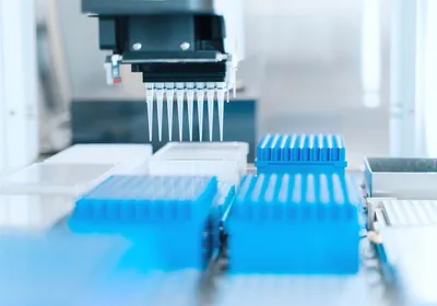 Automated liquid handling system with a multichannel pipette positioned above microplates for library preparation workflow.