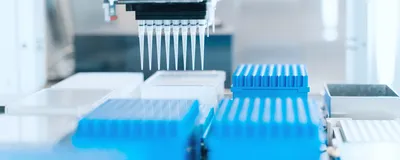 Automated liquid handling system with a multichannel pipette positioned above microplates for library preparation workflow.