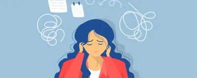 A female student sits at a desk looking at a notebook and looking concerned. 