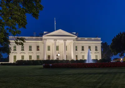 The White House is shown lit up at night.