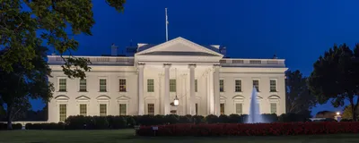 The White House is shown lit up at night.