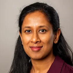 Chathurani Ranathunge wears a purple shirt against a gray background in a headshot.