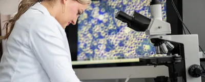 Scientist reviewing cellular and molecular data on a computer in a laboratory.