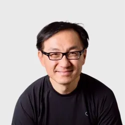 Chris Fang wears a black shirt and black-rimmed glasses in a headshot.