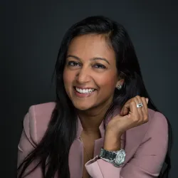 A photograph of Rashmi Kudesia wearing a pink jacket.