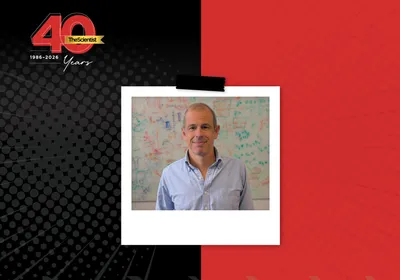 Tiago Branco wears a light blue shirt and stands in front of a white board in The Scientist’s 40th Anniversary Then and Now story template.