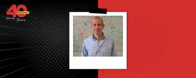 Tiago Branco wears a light blue shirt and stands in front of a white board in The Scientist’s 40th Anniversary Then and Now story template.