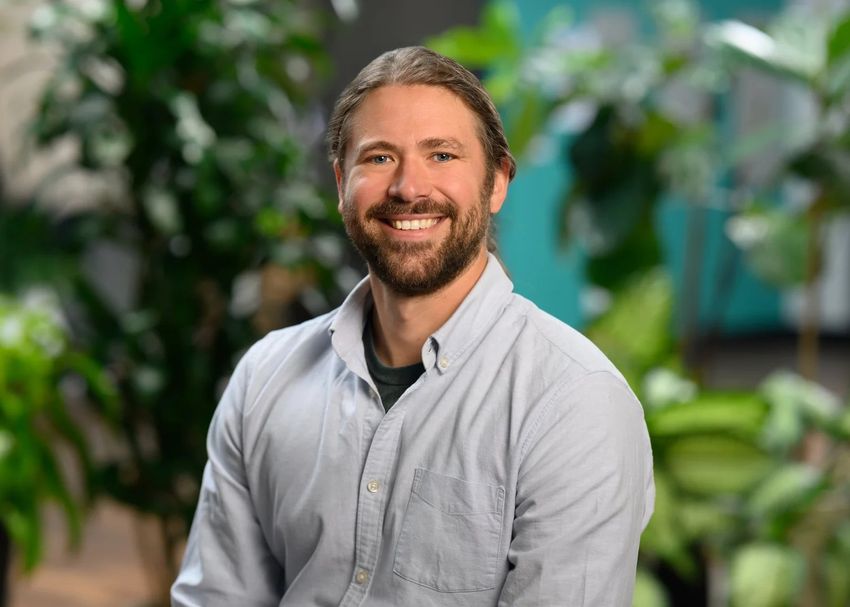 A photograph of Cameron Pye wearing a light-colored shirt against a natural background. A photograph of Cameron Pye wearing a light-colored shirt against a natural background.