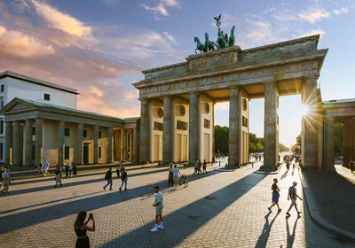 A view of the Brandenburg Gate in Berlin at sunset.