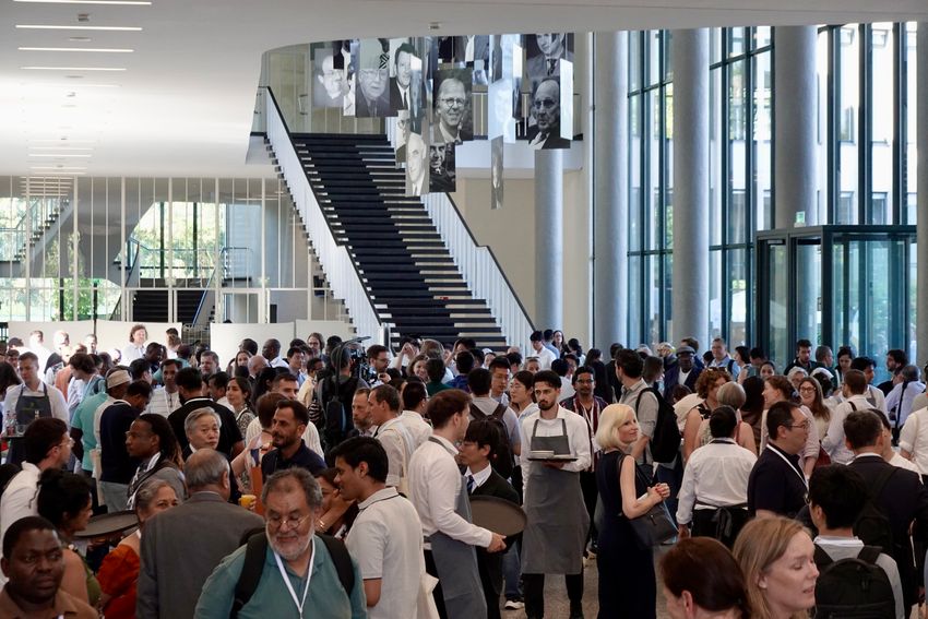 A crowd of people gather in a university hall