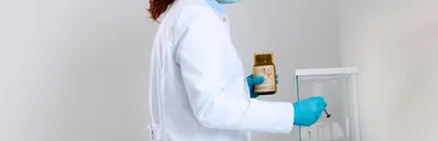 A scientist weighing a powdered reagent on an analytical balance