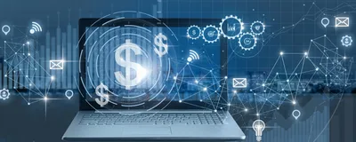 A laptop screen displaying illuminated digital network nodes, financial graphics, and a dollar sign symbol.